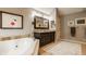 Luxury bathroom boasts a modern dark wood vanity, jacuzzi, and elegant decor at 2055 Mulsanne Dr, Zionsville, IN 46077