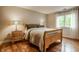 Bright bedroom with a wood frame bed, wooden floors, and a light-filled window at 2055 Mulsanne Dr, Zionsville, IN 46077