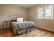 Well-lit bedroom with wood floors, decorative bed frame, and a view to the outside at 2055 Mulsanne Dr, Zionsville, IN 46077