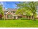 Brick home with manicured lawn, mature tree, and beautiful landscaping at 2055 Mulsanne Dr, Zionsville, IN 46077