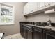 A functional laundry room with stainless sink, black granite countertop and neutral paint at 2055 Mulsanne Dr, Zionsville, IN 46077