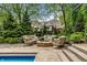 A cozy outdoor seating area with a fire pit and comfortable furniture surrounded by green landscaping at 2055 Mulsanne Dr, Zionsville, IN 46077