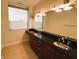 Bathroom vanity with double sinks, dark granite countertop, and large mirror at 225 N New Jersey St # 46, Indianapolis, IN 46204