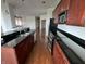 Spacious kitchen featuring black countertops, wood cabinets, stainless steel appliances and hardwood floors at 225 N New Jersey St # 46, Indianapolis, IN 46204