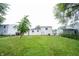 Backyard view of a two-story home, green lawn, and mature trees at 2740 Pawnee Dr, Indianapolis, IN 46229