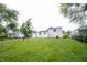 Spacious backyard showcases the home's exterior, a lawn, and a partial tree line at 2740 Pawnee Dr, Indianapolis, IN 46229