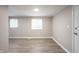 Bedroom featuring wood-look flooring, neutral paint, and two windows at 2740 Pawnee Dr, Indianapolis, IN 46229