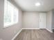 Bedroom featuring wood-look flooring, neutral paint, and large window at 2740 Pawnee Dr, Indianapolis, IN 46229