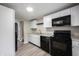 Updated kitchen features white cabinets, granite countertops, and black appliances at 2740 Pawnee Dr, Indianapolis, IN 46229