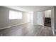 Bright living room featuring wood-look flooring, neutral paint, and staircase access at 2740 Pawnee Dr, Indianapolis, IN 46229