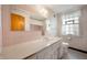 Pink-tiled bathroom with vintage fixtures, ample mirror space, and bright window, combining charm and functionality at 301 N Kitley Ave, Indianapolis, IN 46219