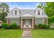 Charming brick home with dormer windows, well-kept lawn, and decorative front porch columns at 301 N Kitley Ave, Indianapolis, IN 46219