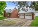 Charming red brick house featuring a two-car garage and a private driveway at 301 N Kitley Ave, Indianapolis, IN 46219