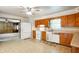 Functional kitchen with wooden cabinets and white appliances, open to living areas at 301 N Kitley Ave, Indianapolis, IN 46219