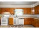 Well-lit kitchen featuring wooden cabinetry, white appliances, and neutral flooring at 301 N Kitley Ave, Indianapolis, IN 46219