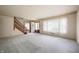 Open-concept living room with staircase and large window, plenty of natural light at 301 N Kitley Ave, Indianapolis, IN 46219