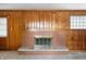 Living room showcasing a brick fireplace, wood paneling, and built-in shelving, creating a cozy focal point at 301 N Kitley Ave, Indianapolis, IN 46219