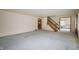 A view of the living room with light blue carpet and a glimpse into the dining room at 301 N Kitley Ave, Indianapolis, IN 46219