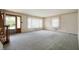 Spacious living room with light blue carpet and multiple windows, featuring a staircase at 301 N Kitley Ave, Indianapolis, IN 46219