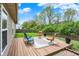 Well-maintained backyard with a wooden deck, patio furniture, and green landscaping at 3214 Limber Pine Dr, Whiteland, IN 46184