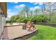 Lush backyard featuring a brick patio, wooden deck, and green lawn at 3214 Limber Pine Dr, Whiteland, IN 46184