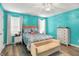 Tranquil bedroom with bright teal walls and complemented by a comfortable bed, modern furnishings and ample natural light at 3214 Limber Pine Dr, Whiteland, IN 46184