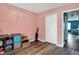 Bedroom featuring wood floors, closet doors, and a view into the blue-painted living area at 3214 Limber Pine Dr, Whiteland, IN 46184