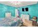 Bright bedroom featuring turquoise walls, modern white furniture, and a stylish geometric bedspread at 3214 Limber Pine Dr, Whiteland, IN 46184