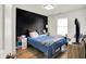 Comfortable bedroom with black accent wall, a cozy bed with soft pillows, and wood-look flooring at 3214 Limber Pine Dr, Whiteland, IN 46184