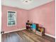 Cozy bedroom with pink walls, organized storage cubes, and a bright window overlooking the yard at 3214 Limber Pine Dr, Whiteland, IN 46184