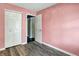 Bedroom featuring wood floors, closet doors, and a view into the blue-painted living area at 3214 Limber Pine Dr, Whiteland, IN 46184