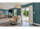 Well-lit living room with a cozy swivel chair, view of the backyard patio and modern lighting at 3214 Limber Pine Dr, Whiteland, IN 46184