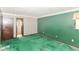 An empty bedroom with green carpet and wallpaper, awaiting your personal touch to create a cozy retreat at 3325 Broadview Ct, Indianapolis, IN 46227