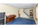 Spacious living room with blue carpeting, a piano, and a staircase leading to the upper level at 3325 Broadview Ct, Indianapolis, IN 46227