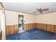 Bright living room with blue carpeting, wood-paneled walls, and a view into another room at 3325 Broadview Ct, Indianapolis, IN 46227