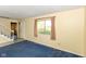 Inviting living room featuring blue carpeting, a window with curtains, and a staircase in the background at 3325 Broadview Ct, Indianapolis, IN 46227