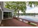 Back deck with bench overlooking a lake with mature trees, and sliding glass doors to home at 3430 Bay Road South Dr, Indianapolis, IN 46240