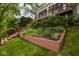 The backyard offers layered landscaping, a deck, and a staircase leading to the upper level at 3430 Bay Road South Dr, Indianapolis, IN 46240