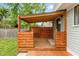 Covered back porch with wood deck and privacy screen, providing a cozy outdoor space at 3614 Guilford Ave, Indianapolis, IN 46205