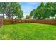 A well-maintained, grassy backyard enclosed by a wooden fence under a clear blue sky at 405 N Drexel Ave, Indianapolis, IN 46201