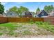 Wide backyard with a wooden fence separating grassy area from parking spot near neighboring houses at 405 N Drexel Ave, Indianapolis, IN 46201