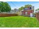 Backyard featuring a lush green lawn, a wooden fence, and a deck at 405 N Drexel Ave, Indianapolis, IN 46201