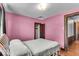 Cozy bedroom with hardwood floors, pink walls, and a double bed at 405 N Drexel Ave, Indianapolis, IN 46201