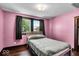 A bedroom features a pink color scheme, hardwood floors, and a window with dark curtains at 405 N Drexel Ave, Indianapolis, IN 46201
