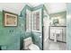 A quaint bathroom features a shower/tub combo, unique paint, and a pedestal sink at 5002 Broadway St, Indianapolis, IN 46205