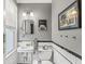 A charming bathroom featuring white fixtures, subway tile, and a classic black and white color scheme at 5002 Broadway St, Indianapolis, IN 46205