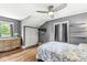A cozy bedroom features gray walls, hardwood floors, and a decorative ceiling fan at 5002 Broadway St, Indianapolis, IN 46205