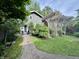 Charming home with a wooden pergola and a brick path leading to the entrance at 5002 Broadway St, Indianapolis, IN 46205