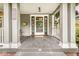 Inviting covered front porch with classic columns, a charming entrance, and a hanging bicycle decor at 5002 Broadway St, Indianapolis, IN 46205