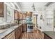 A kitchen featuring stainless steel appliances, dark wood cabinets, stone counters and updated lighting at 5002 Broadway St, Indianapolis, IN 46205